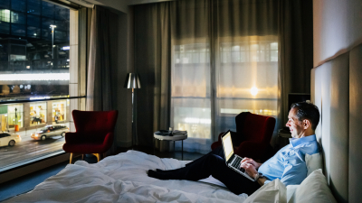 Person sitting on a bed with a laptop at night 